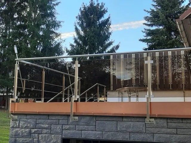 Terrasse mit Metallgeländer und angrenzendem Garten