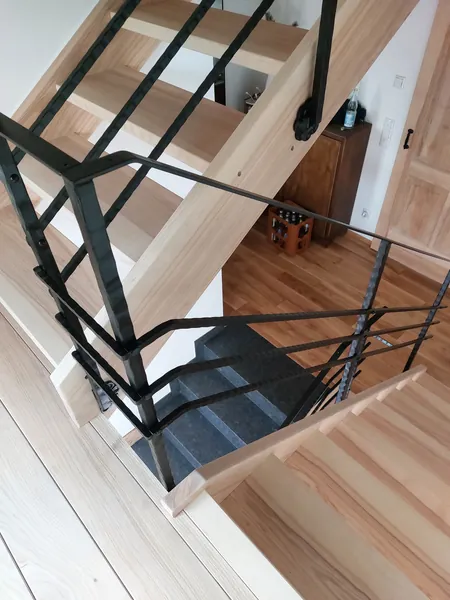 Blick ins Treppenauge mit schwarzem Metallgeländer