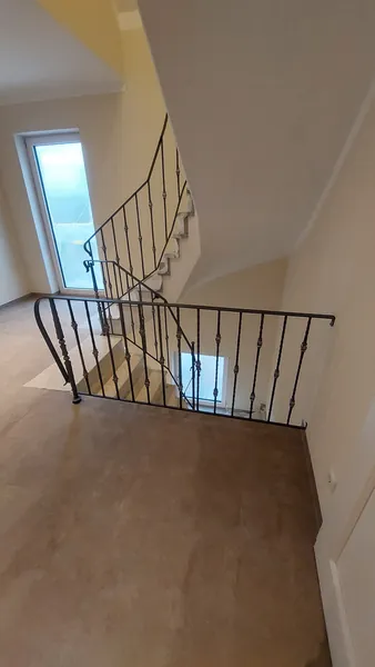 Blick von oben auf ein Treppenhaus mit geschmiedeten Geländern