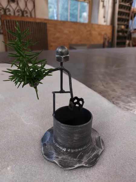 Dekorative Figur aus Metall mit Pflanzgefäß