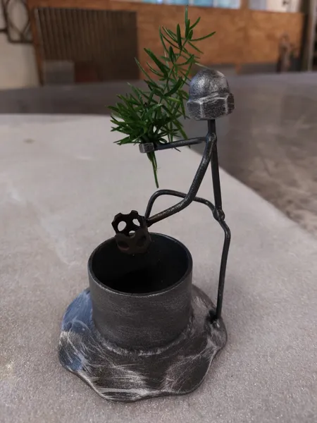 Dekorative Figur aus Metall mit Pflanzgefäß