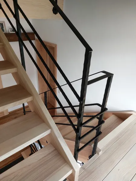 Geländerantritt an einer offenen Holztreppe