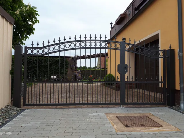 Geschmiedete Toranlage mit dekorativen Metallelementen