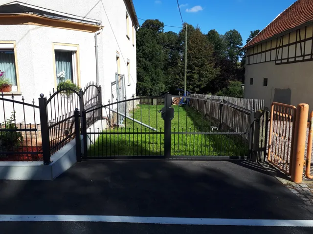 Geschmiedete Toranlage mit dekorativen Metallelementen