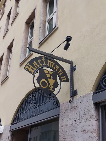 Geschmiedeter Ausleger mit Zunftzeichen an einer Fassade