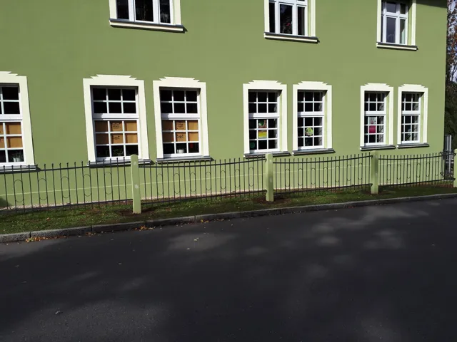 Metallzaun entlang einer Hausfassade