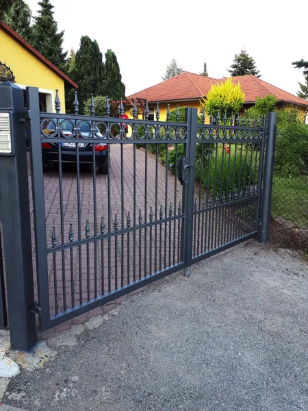 Metallzaun mit Tor und dekorativen Stäben