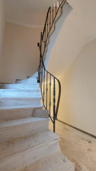 Seitliche Ansicht eines geschmiedeten Geländers an einer Steintreppe