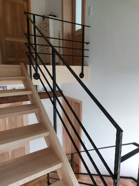 Seitliche Ansicht eines Metallgeländers an einer Holztreppe
