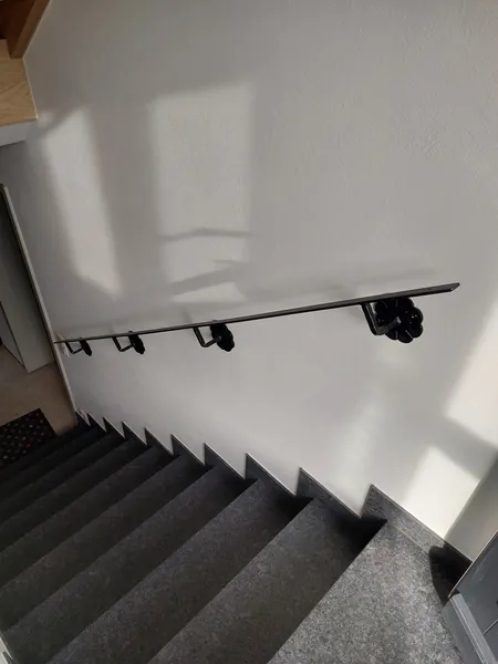 Wandhandlauf mit geschmiedeten Halterungen über einer Steintreppe