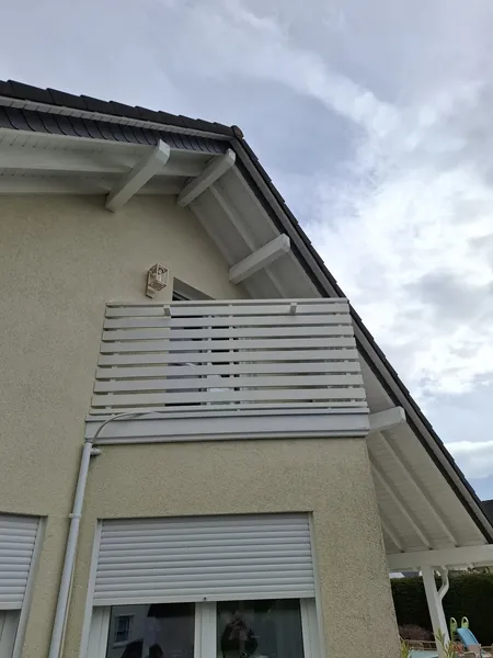 Balkongeländer mit Sichtschutzlamellen an einer Hausfassade