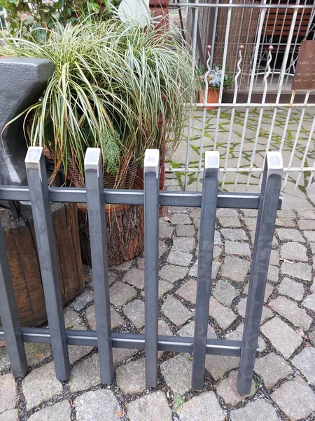 Detail eines Zaunelements mit senkrechten Metallstäben