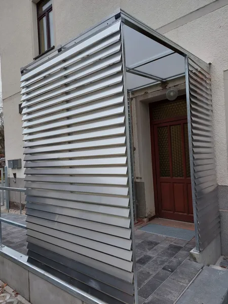Eingangsbereich mit Metalllamellen und Geländer
