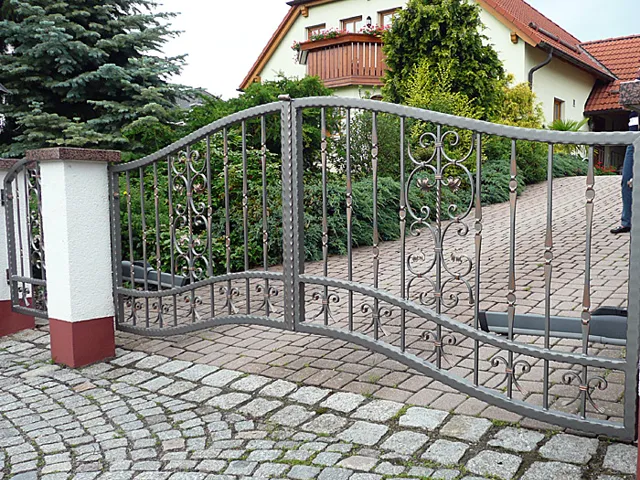 Geschmiedete Toranlage mit dekorativen Metallelementen