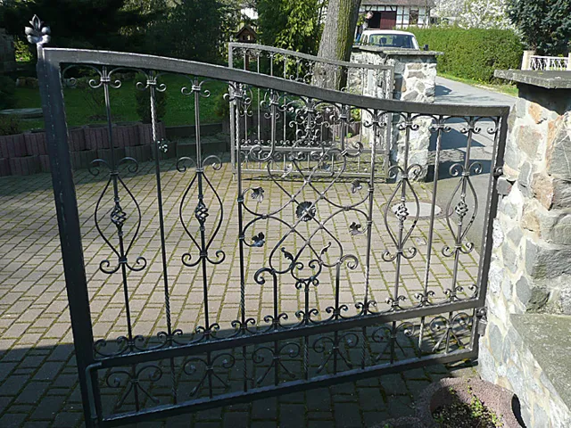 Geschmiedete Toranlage mit dekorativen Metallelementen