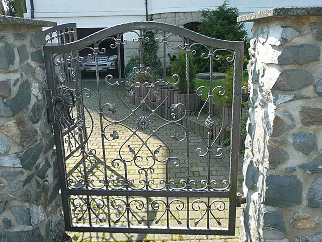 Geschmiedete Toranlage mit dekorativen Metallelementen