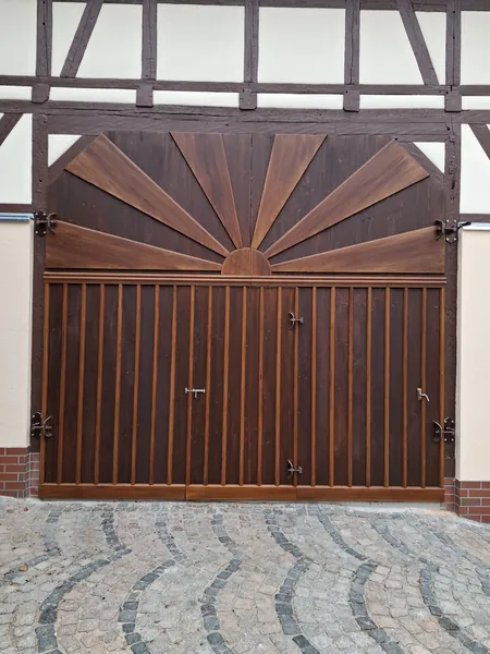 Großes Hoftor mit Holzfüllung unter einem Fachwerkgiebel