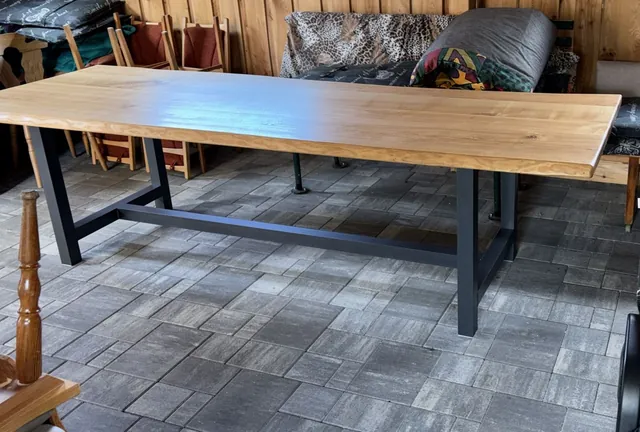 Langer Holztisch mit dunklem Metallgestell und Querstrebe