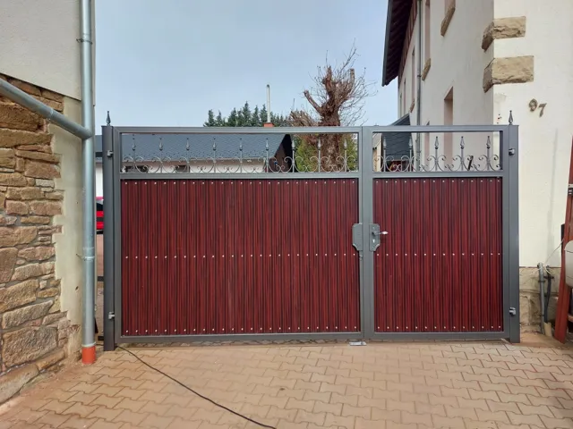 Metalltor mit roten Füllungen und senkrechten Stäben
