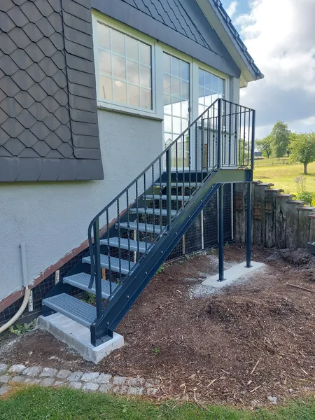 Metalltreppe mit Gitterroststufen zu einem erhöhten Eingang