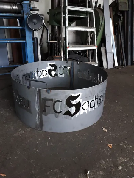 Runde Metallschale mit ausgeschnittenem Schriftmotiv