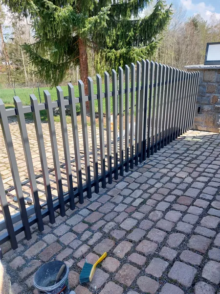 Seitliche Ansicht eines Stabtors zwischen Natursteinpfeilern