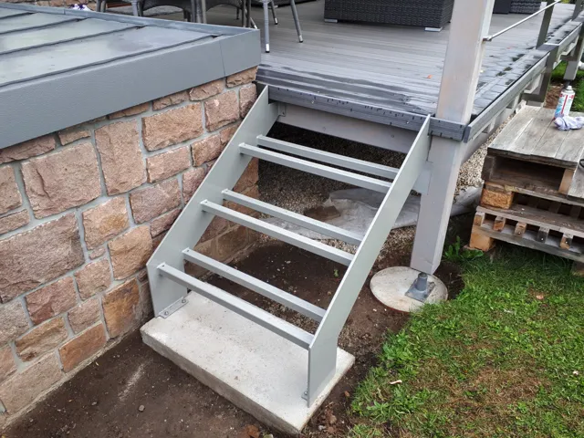 Terrasse mit Metallgeländer und angrenzendem Garten